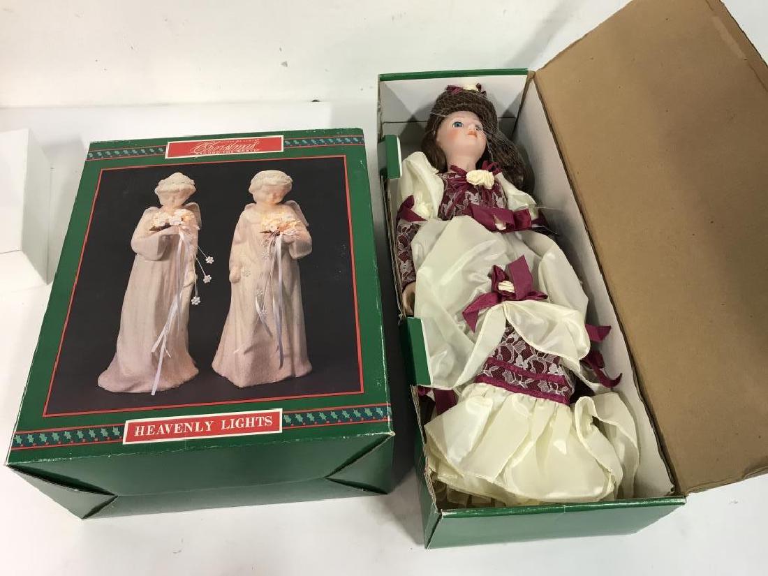 Set of 2 HOUSE OF LLOYD Christmas Doll & Lights: HOUSE OF LLOYD Christmas collection including a porcelain doll in one box, and two angel figurine lights (possibly ceramic). Doll and lights both come in original boxes. Boxes have been opened, althou