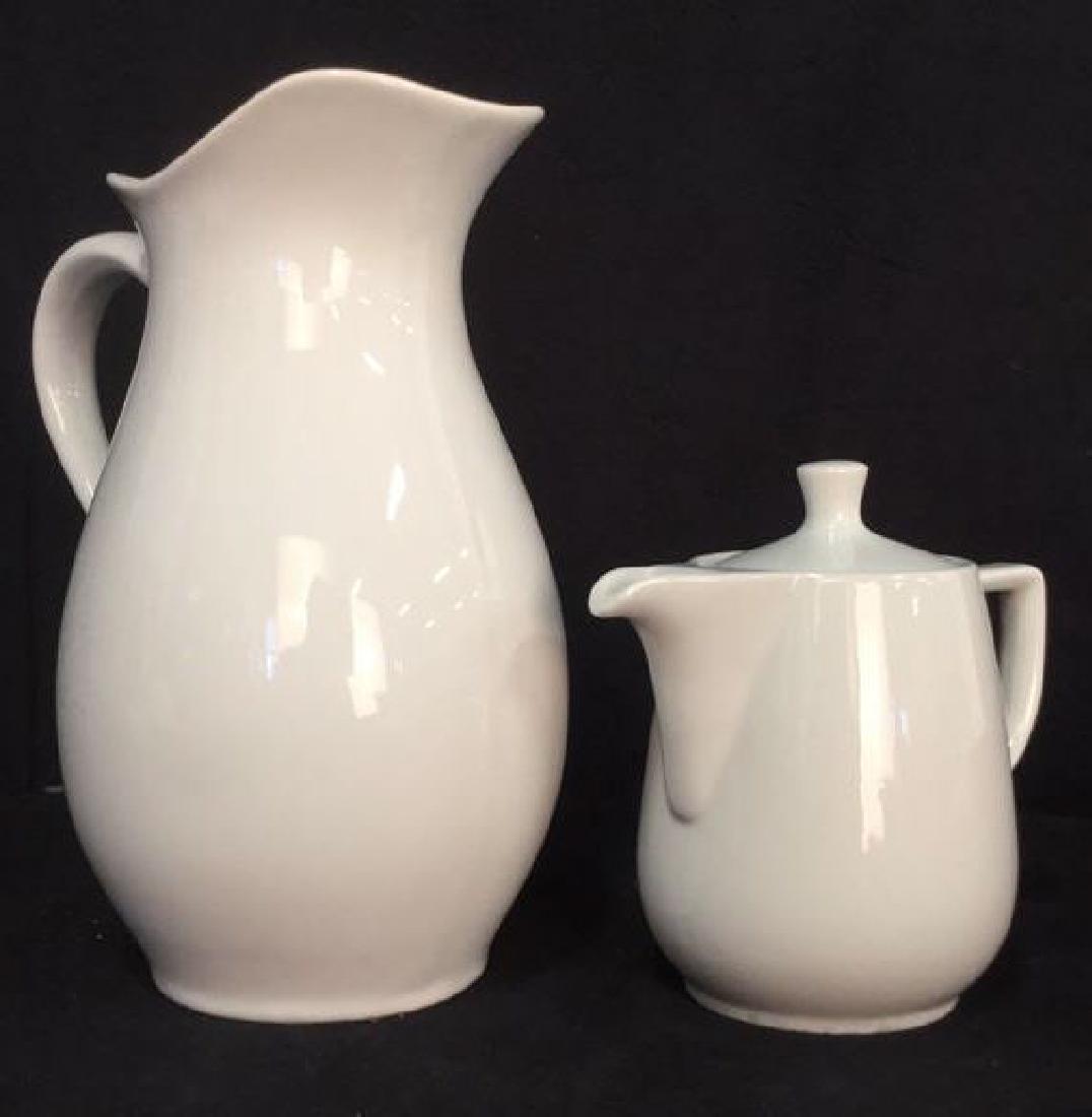 Lot 2 White Porcelain Pitcher & Teapot: Teapot is marked GEVALIA KAFFE and pitcher is marked THRESHOLD. Pitcher measures approx 11.5 inches tall 9 inches wide. Teapot includes lid. Tableware, tabletpo accessories, pitchers, teapot