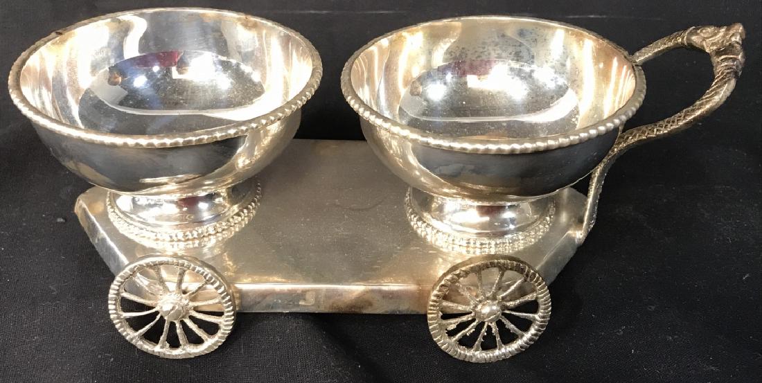 Silver Toned Metal Condiment Cart: Condiment cart has 2 basins, 4 wheels and 1 handle. Contains some wear. Measures approx 9 inches long 3.5 inches tall and wide. Serving dish, condiment dish, tableware, decorative tabletop accessory. 