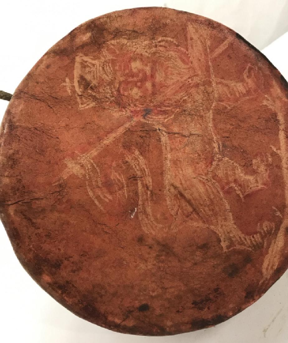 Lion of Judah Animal Skin Drum, Pos Ethiopian: Animal skin handheld drum with Lion of Judah emblem, possibly Ethiopian or Eritrean in origin. Drum has seeds or beads inside to make rattling noise. Drum has surface wear consistent with age. Approxi
