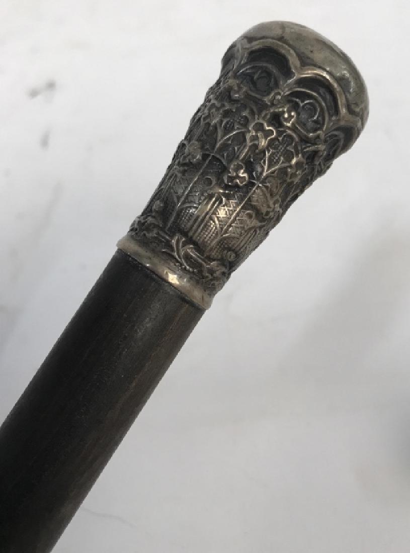 Vintage Wooden and Embossed Silver Tone Metal Cane: Vintage wooden and embossed silver tone walking cane. Came is made up of deep ash brown tone wood with silver tone metal details. Top handle has embossed floral pattern. Cane has surface wear / minor