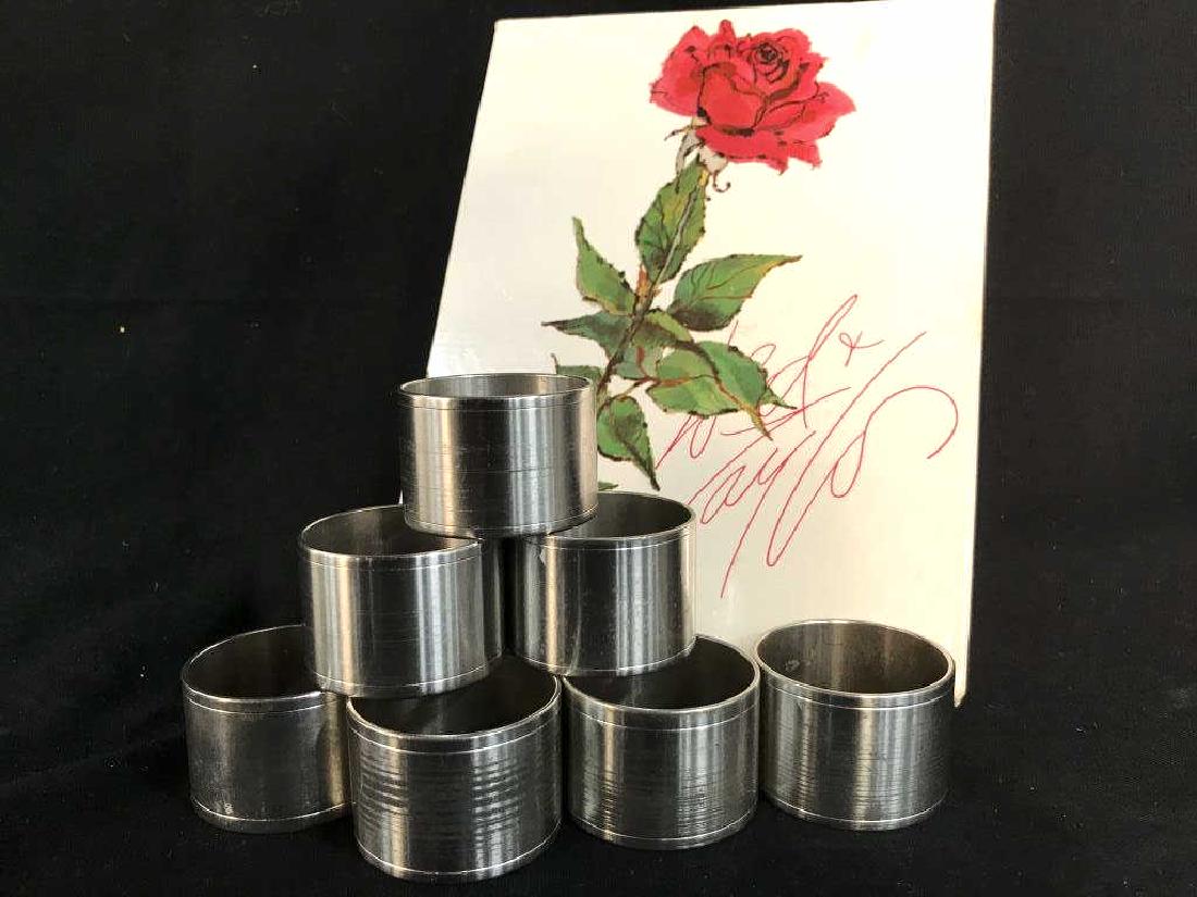 Set 8 Lord & Taylor Silver Tone Metal Napkin Rings: Set of 8 Lord & Taylor silver tone metal napkin rings in original box. Napkin rings have some surface wear, might need polishing. Napkin ring measures approx 1.5 inches in diameter by 1.1 inches in he
