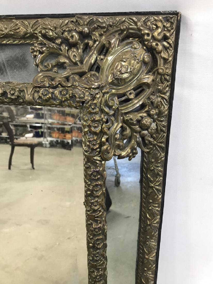 Antique Flemish Style Cushion Mirror: A highly decorative antique/vintage Flemish style cushion mirror. Intricately Detailed mirror of cushion form with a black toned painted wooden base with pierced repousse brass toned metal floral deco