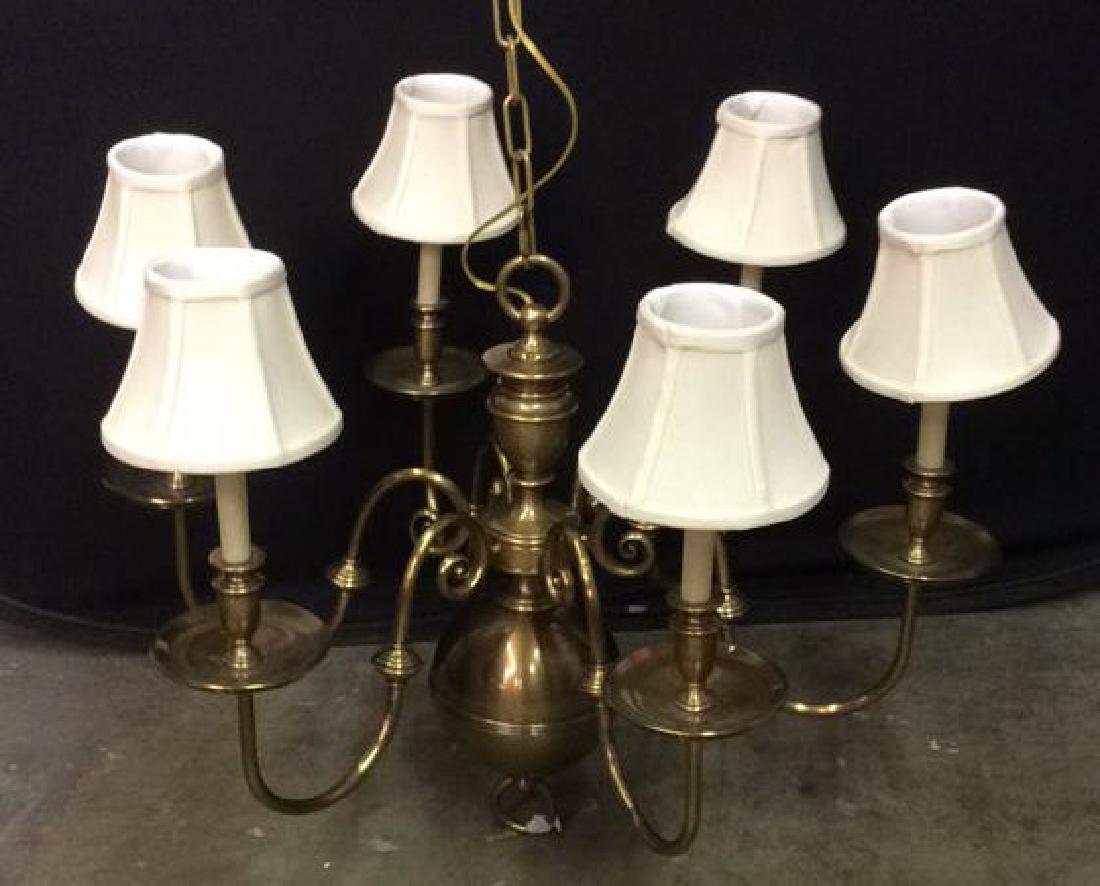 Gold Toned Brass 6 Armed Chandelier: Gold toned brass chandelier contains swirled arms and a spherical center column. DOES NOT INCLUDE SHADES. Measures approx 51 inches tall x 32 inches wide. Home Lighting. Dining room lighting. Hanging 