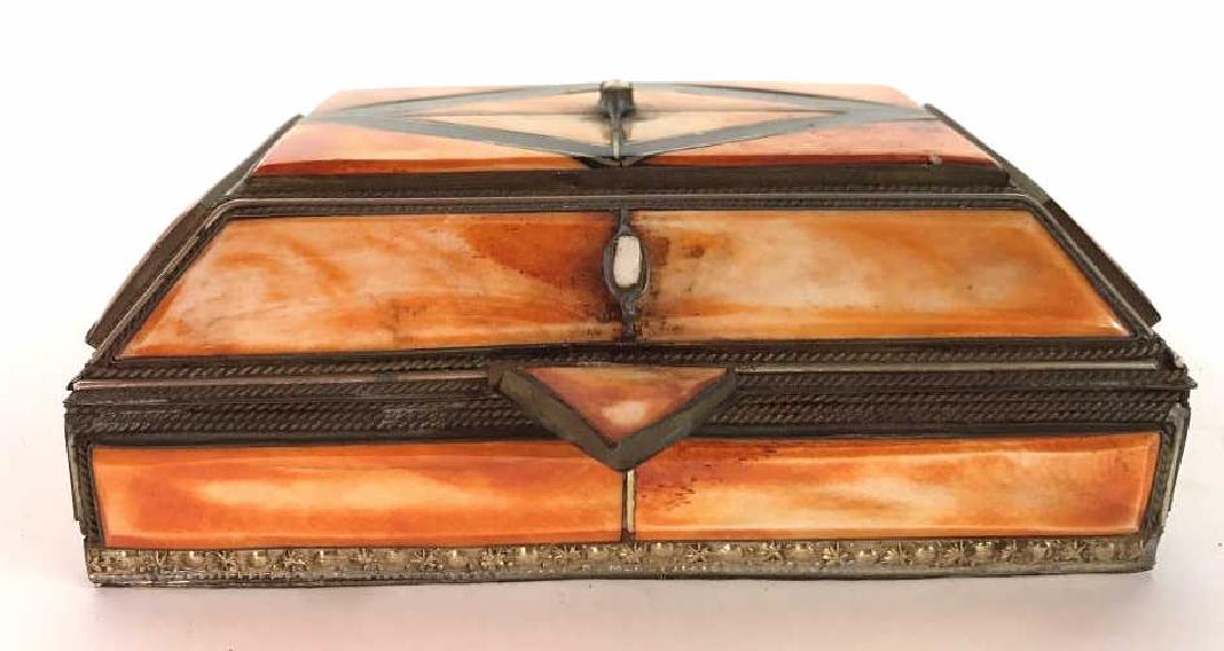 Bone & Brass Trinket Box: Trinket box is orange & gold toned. Appears to be carved bone and brass with maroon toned fabric inside. Piece measures approx 6 inches long 4 inches deep 2.5 inches tall. Desktop accessory, keepsake 