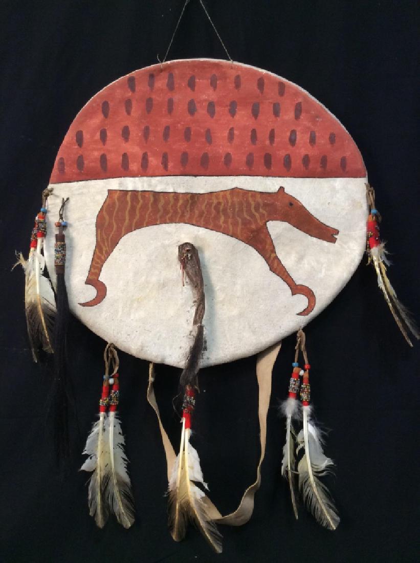 American Indian War Shield with Coyote Tail: American Indian War Shield with Coyote Tail, 19 in diameter, 29 in at longest point to end of Feathers, possibly antique, Painted hide with red coyote and adorned with Coyote tail and beaded feathers,