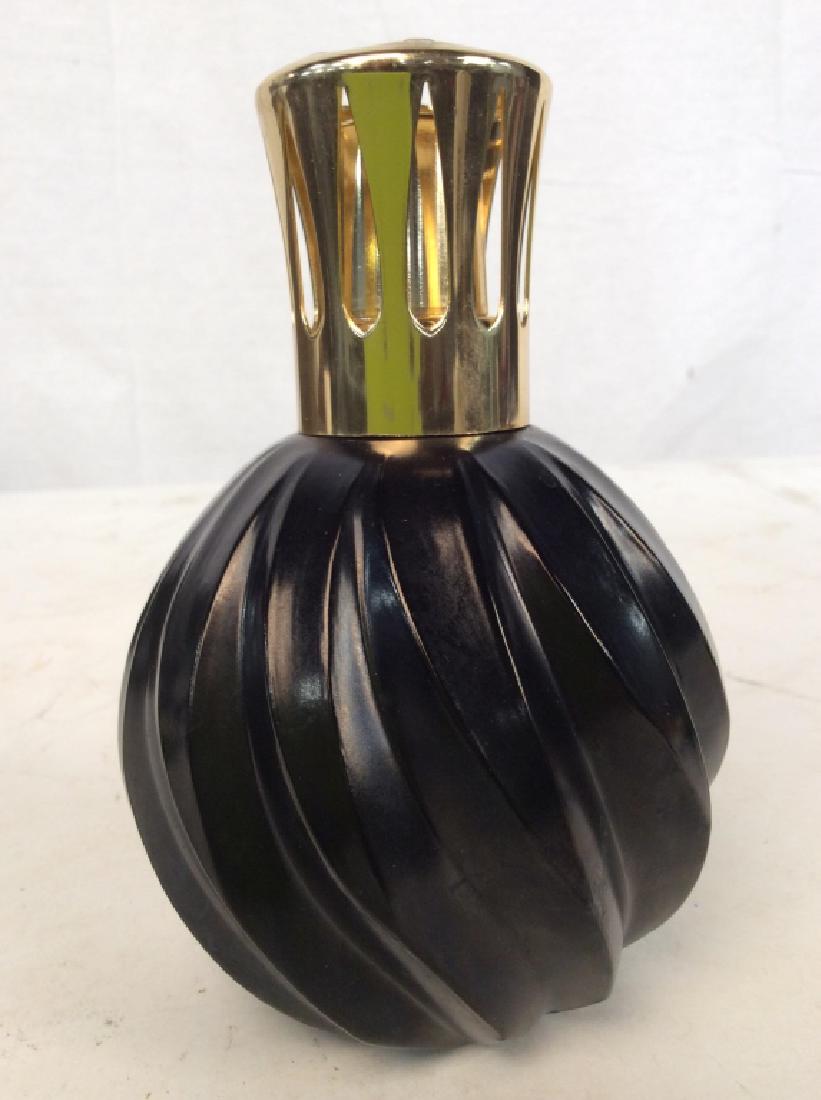 Lampe Berger Fragrance Lamp: Lamp Berger Fragrance Lamp, 6 in x 4 in at widest point, Black fluted Body, possible glass or porcelain body Gold Toned Top, Top Marked Made in France, nearly unused, Marked underside Lampe Berger, Co