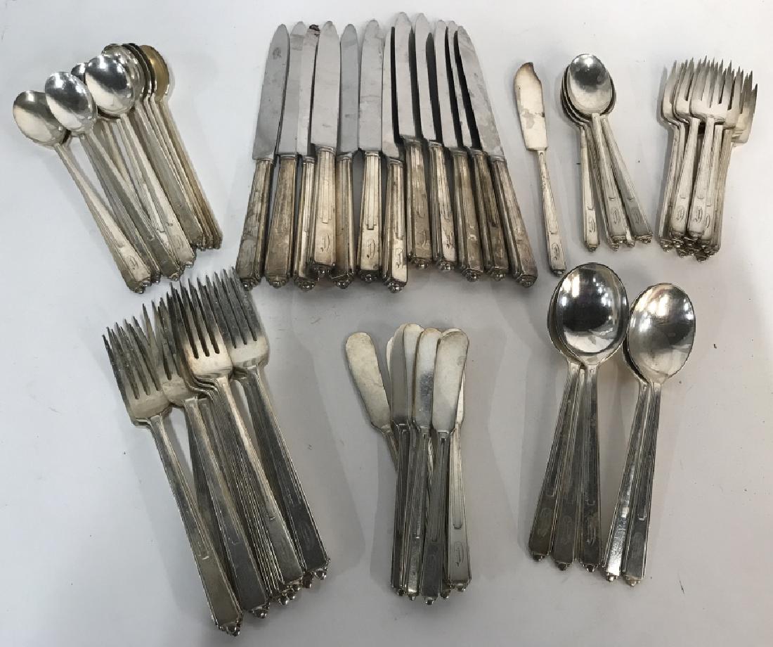 68 Piece Set Reed & Barton Art Deco Flatware: Approximately 68 piece set of Reed & Barton silver plate flatware. Set is in the Art Deco, modernist pattern called ‘Maid of Honor.’ Each piece is monogrammed. Largest piece in set, the dinner kni