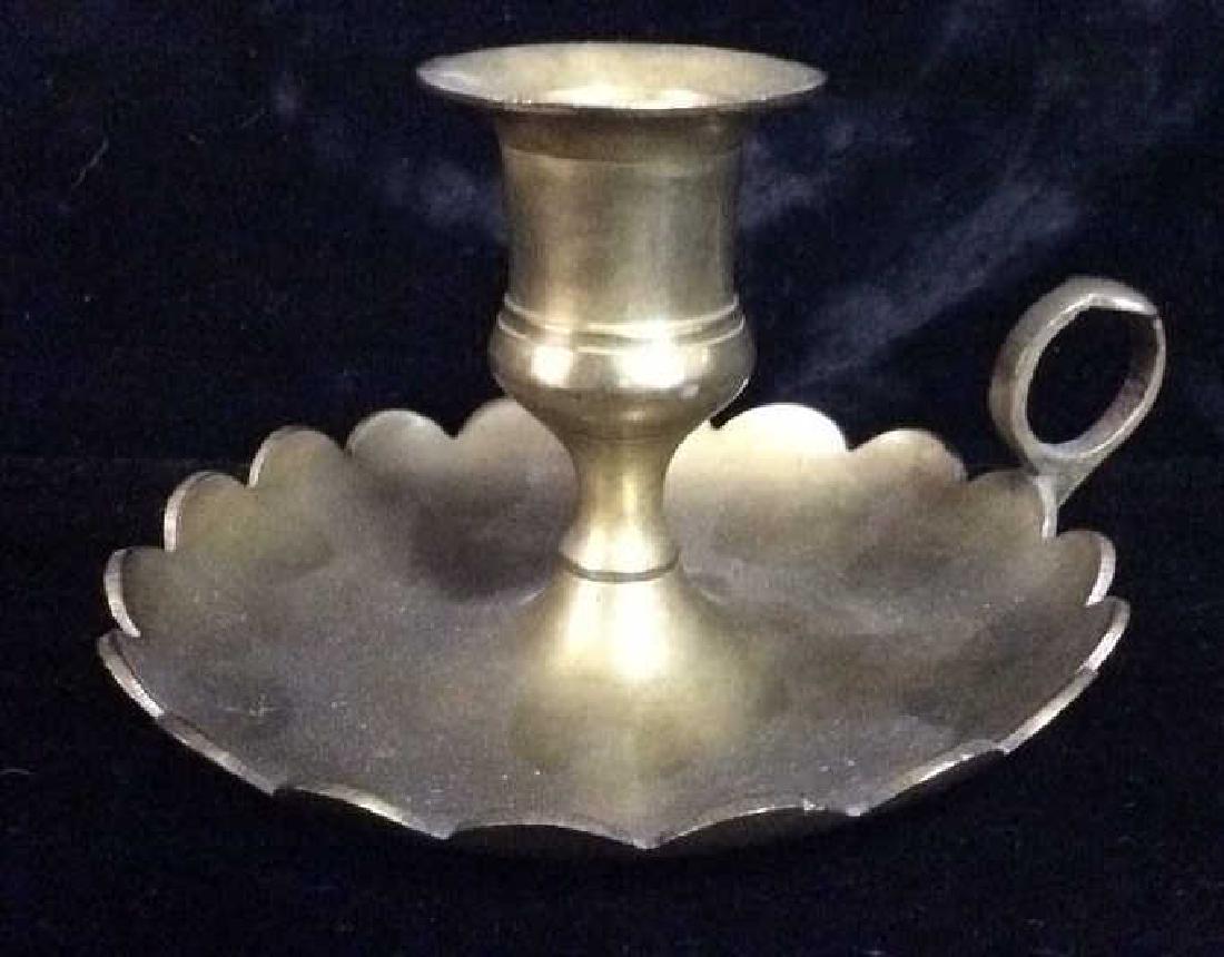Brass Toned Metal Candle Holder: Brass Toned Metal Candle Holder With handle and scalloped edges catch dish, some minor surface wear including dent in catch dish Measures approx 3 1/2 in tall by 5 1/2 in by 5 in. Home accessory, tabl