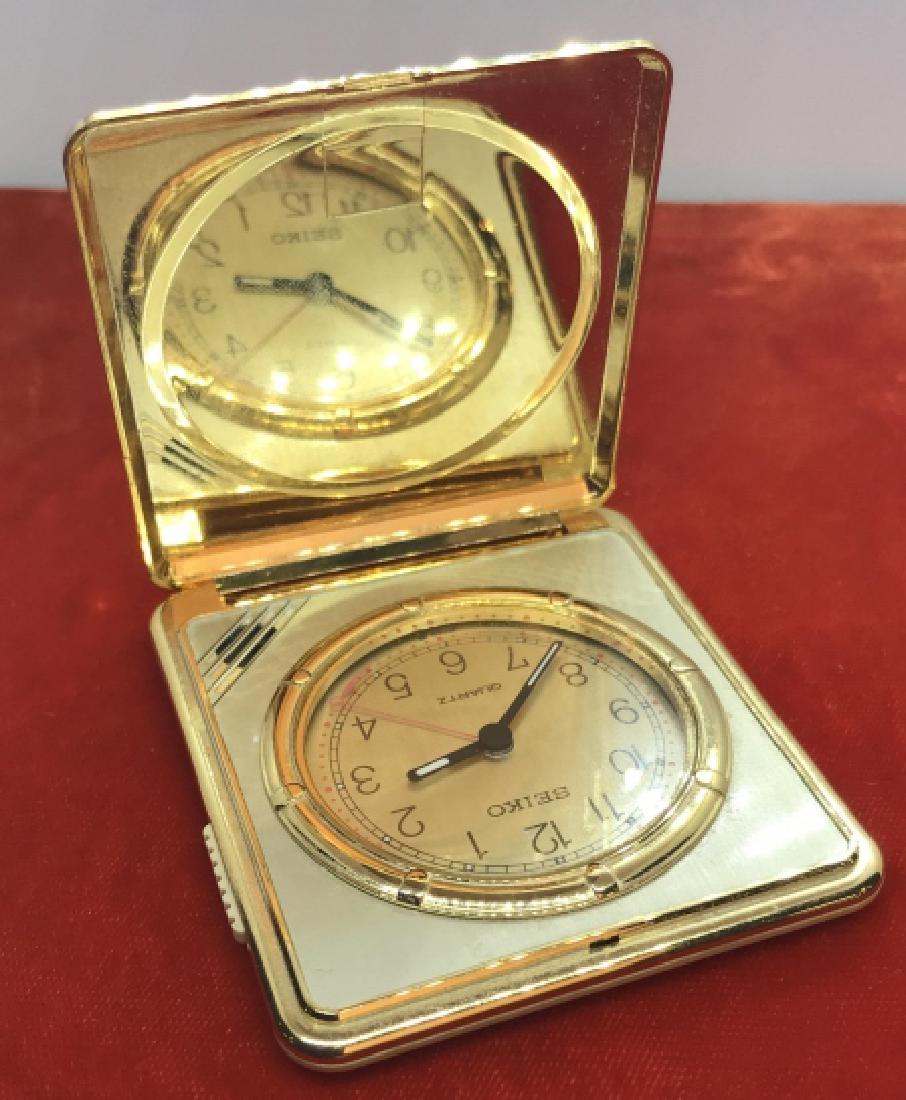 Seiko Gold Tone Pocket Watch in Square Case: Seiko gold tone pocket watch in square case. Hinges on case are missing. Case appears to be plastic. Watch Has not been tested. Measures approx 2.75 inches squared. Vintage pocket wallet watch, vintag