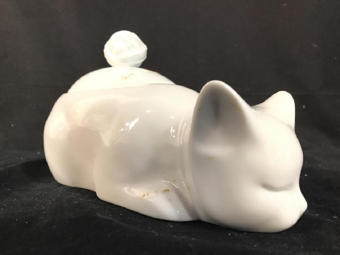 SCHMID FOLIO DESIGN Porcelain Cat Jar: Underside reads SCHMID FOLIO DESIGN. Pieces shape resembles a cat. Top of piece has lid with handle and 6 holes. Measures approx 9.5 inches long 5 inches tall. tableware, tabletop accessory, decor pie