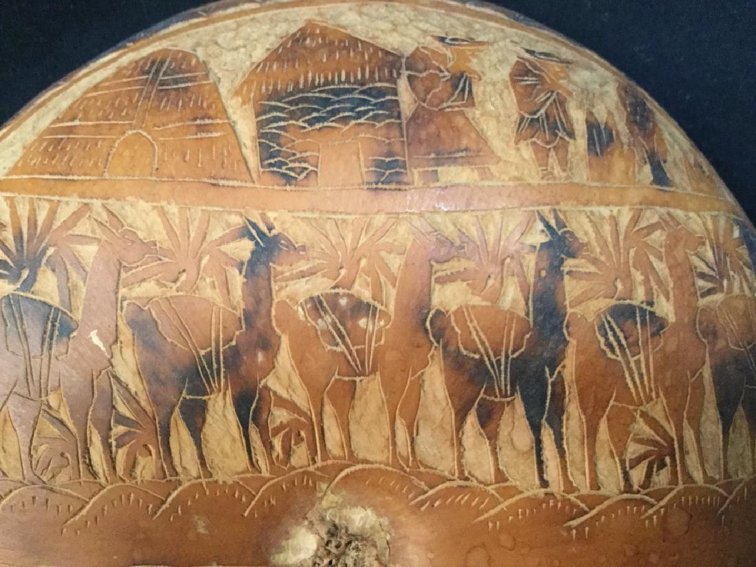Gourd Shell Bowl W Carved Patterned Exterior: Shell bowl, possibly from a gourd, with decoratively carved patterned exterior. Pattern depicts figures and llamas, possibly Central or South American in origin. Measures approx 2 inches in height by 