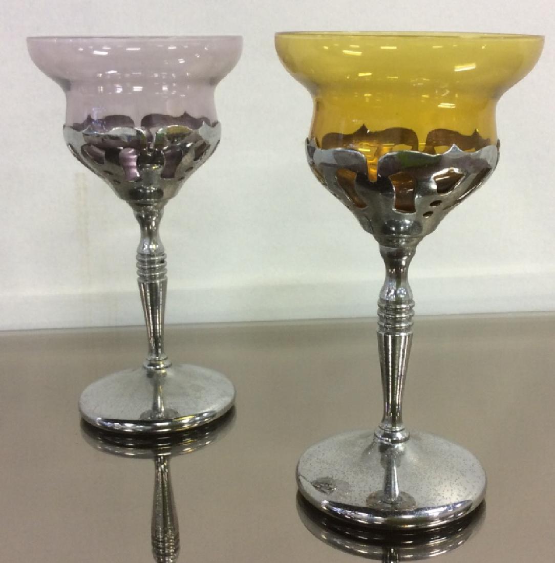 Pair of Colored Glass & Metallic Stemmed Chalices: Pair of chalices / drinking glasses / wine glasses with colored glass cups and silver toned metal stems. Glasses are purple & yellow in tone. Approximately 6 inches in height by 3 inches in diameter. 