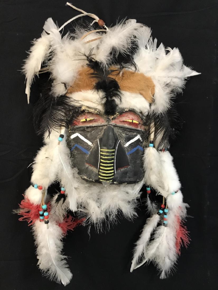 Vintage Native American Decorative Mask: Vintage Native American decorative display mask. Mask is composed of papier-mache on plastic. Mask is painted with black, red, yellow, and white tones with multicolor feather and faux fur details. Mas