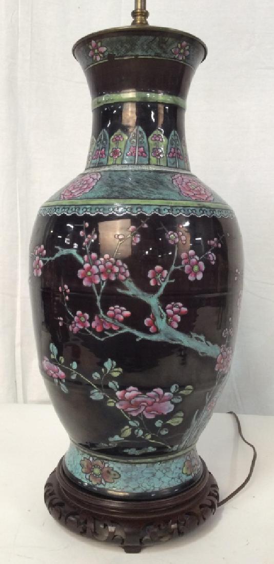 Antique Chinese Ceramic Table Lamp: Antique Chinese Ceramic Table Lamp, 35 in x 9 in, on Carved wooden stand, decorated with pink cherry blossom boughs on clack ground, Good condition, greens, pinks, and black, Asian Arts and Crafts, As