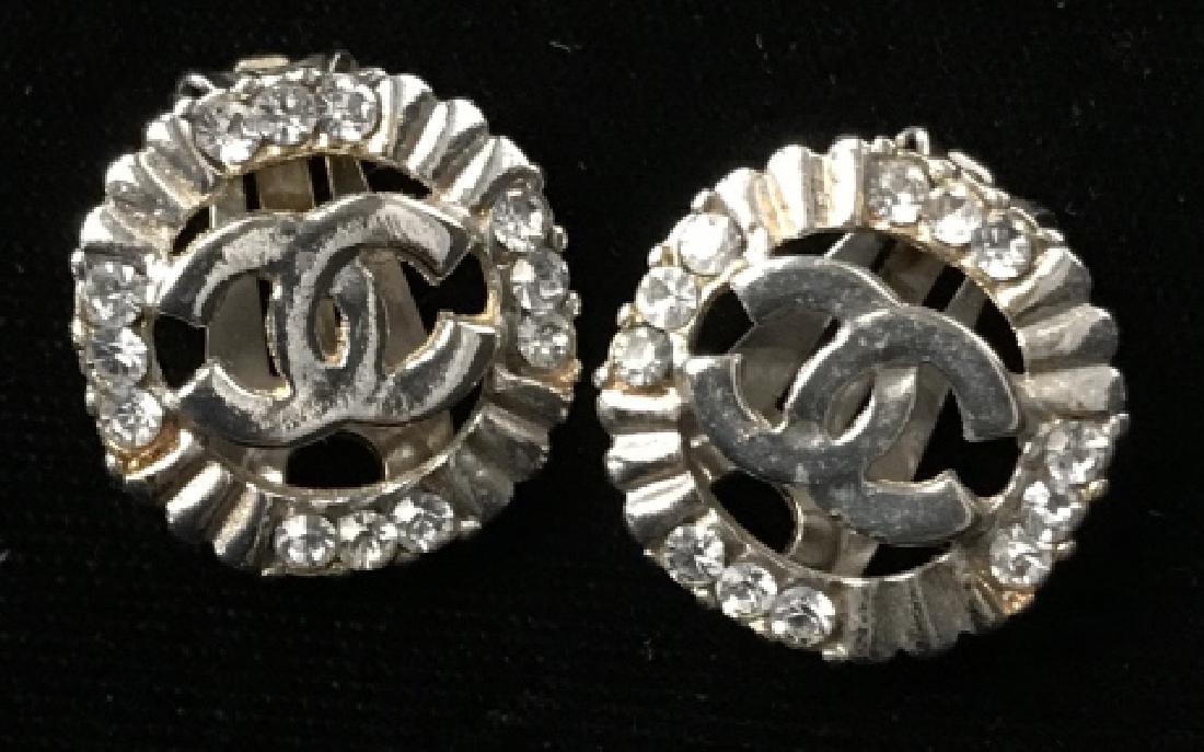 Chanel Style Rhinestone Earrings: Chanel Style Rhinestone Earrings, circular silver and gold toned metal clip earrings with rhinestones and lined design around outside edges and classic Chanel symbol on interior of interlocking CC, me