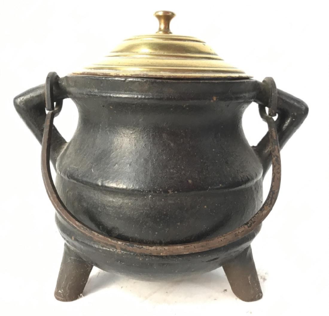 Footed Lidded Cast Iron Cauldron: Cauldron is Cast Iron And Footed. Cauldron Lid is gold toned. Cauldron also has handle. Measures approx 8 inches wide with handles, 7 inches tall. tableware, tabletop accessory, decor piece rustic hom