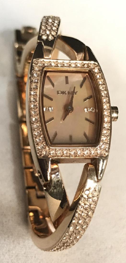 DKNY Rose Gold Toned Rigid and Link Watch: DKNY RosebGold Toned Rigid and Link Watch, case 1/2 x 7/8 in, band 2 1/2 in, not tested but case and band in good condition, pink rhinestones and rose gold twisted bar length twists, back of case mark