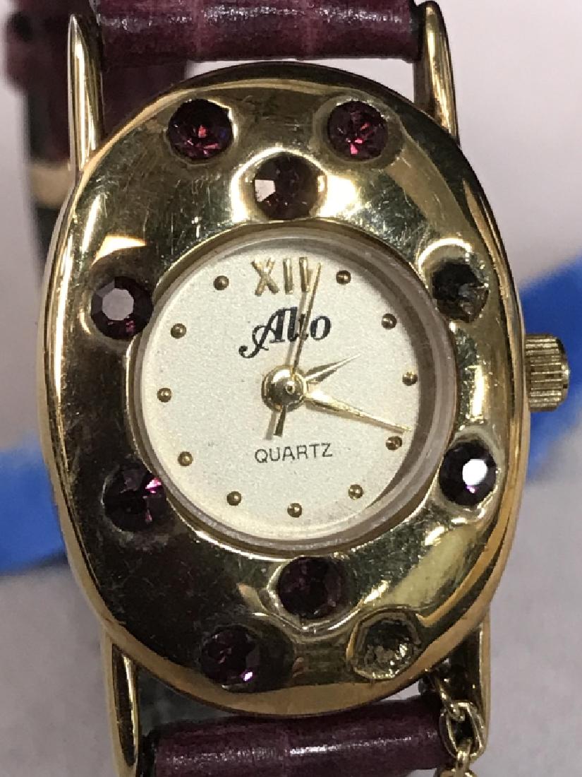 Alto Burgundy leather and Gold Metal Watch: Alto Burgundy leather and Gold Metal Watch, case measure 1 in x 7/8 in, not tested but case and band in good condition, marked stainless back on underside, case has red stones on face, Roman numerals,
