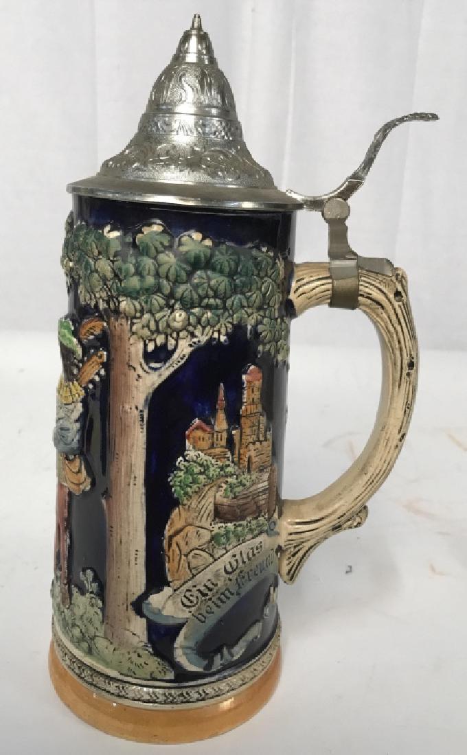 Porcelain Pewter German Beer Stein: With figures and Forrest scenes in relief, hinged pewter Lid, marked underside for Western Germany and H trademark, ht app 11 inches depth to handle app 6 inches, collectible vintage ceramic stein, ba