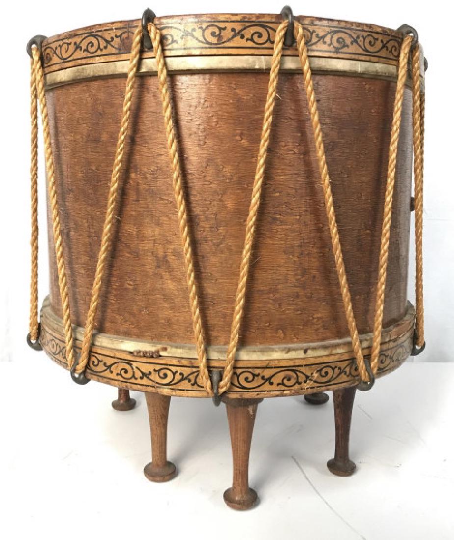 Vintage Drum Side Table On Wooden Pegged Feet: Vintage Possibly Antique Wooden Drum converted into a side table with glass top and pegged wooden feet and hand painted black toned scroll design around top and lower edges, measures approximately 17.