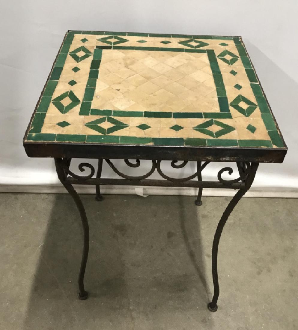 Indoor Outdoor Iron Side Table W Tile Surface: indoor or Outdoor iron side table / stand with tile surface. Tiles / mosaics are beige and green in tone, set in concrete. Iron metal frame and legs. Measures approx 21.2 inches in height by 15.75 inc