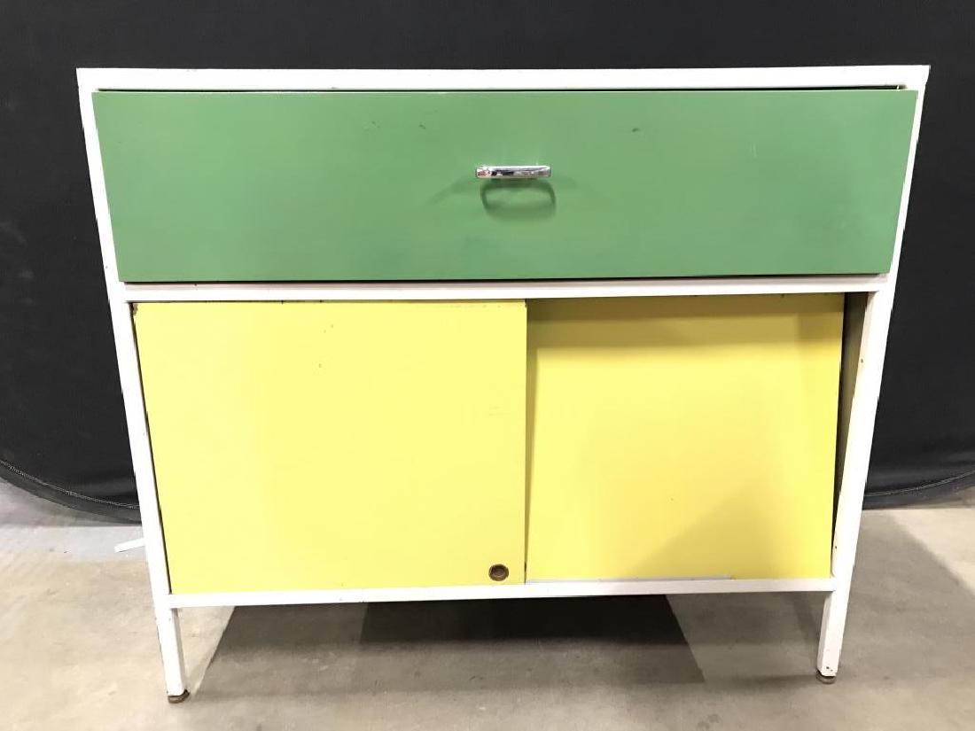 MCM George Nelson for Herman Miller Cabinet: Labeled for George Nelson Designer for Herman Miller, green and yellow geometric, MCM, Industrial modern, Piece has one drawer and sliding cabinet doors. Cabinet doors are yellow toned drawer is green