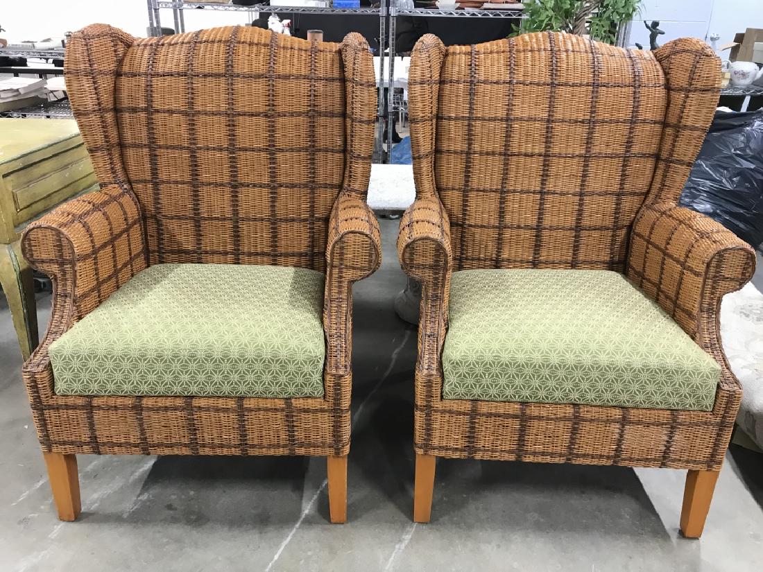 Pair Wicker Wingback Chairs: Chairs are woven wicker. Both include green toned cushions. Pieces have wingback detail, both are beige and brown toned. Each measures approx 42 inches tall 31 inches wide 29 inches deep. Outdoor furn