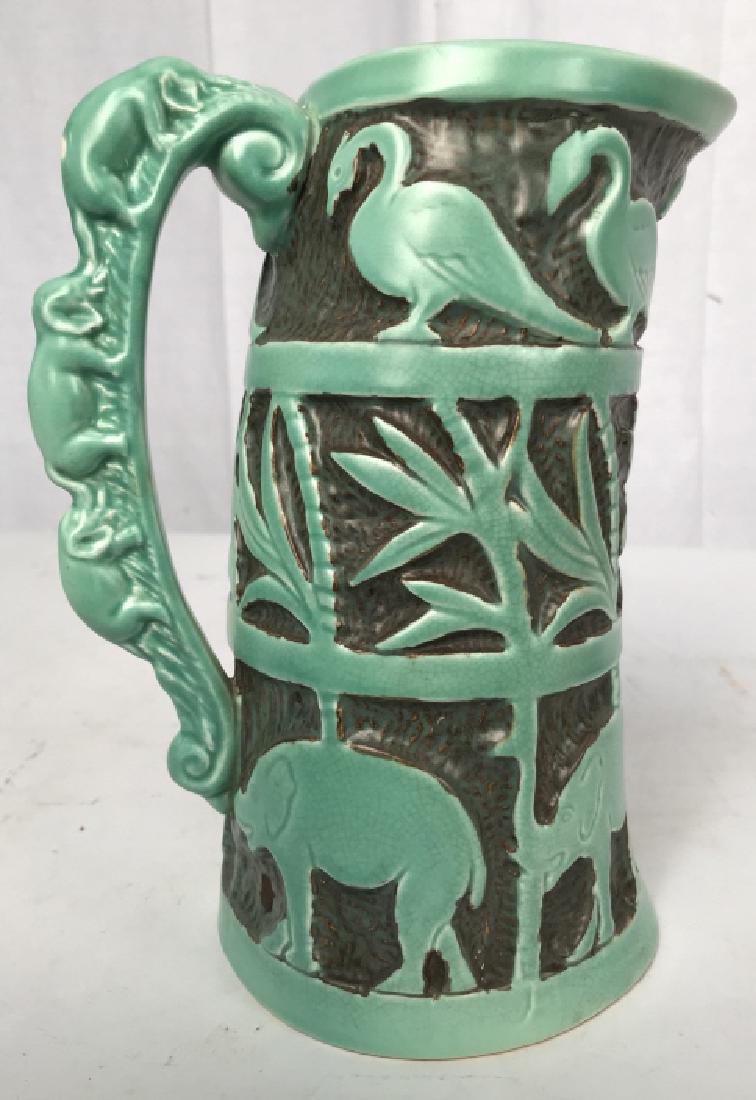 Signed Ceramic Jungle Theme Pitcher, England: Mint green elephants birds, boars, trees and more stand proud in relief encircling Pitcher, Signed underside trademarked and marked for England, bisque matte finish to glaze, vessel, vase, tableware,