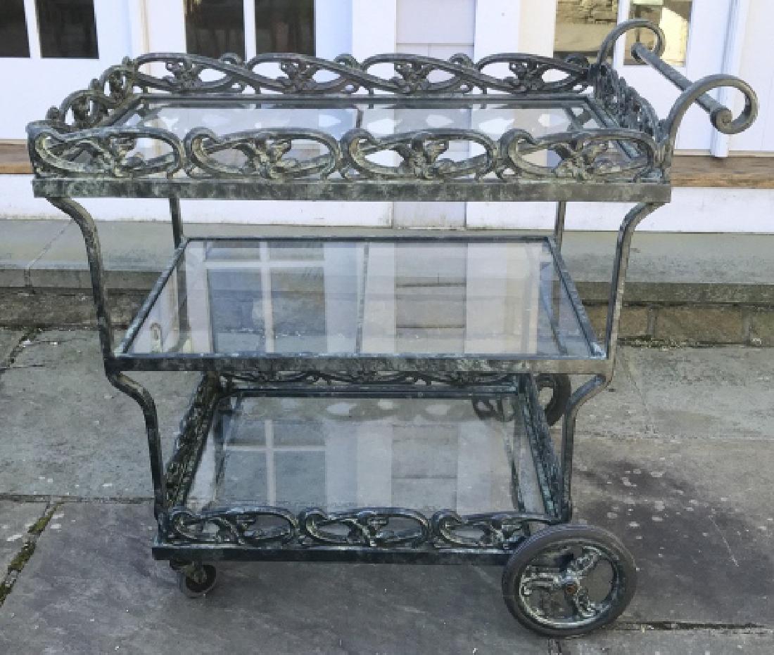 BROWN JORDAN 3 Shelf Tea Cart: Tea cart is metal. Contains floral & vine detail. Piece has 4 wheels & 3 glass levels. Tea cart, beverage cart, outdoor cart. drinks cart, Piece is dark green toned. Measures approx 36 inches long 24