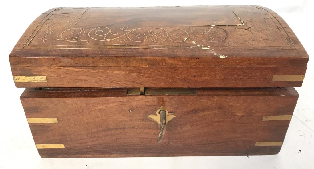 Carved Wooden Jewelry Box W Key: Jewelry box is wooden & light brown toned with gold toned accents. Lid of box has ornate gold toned detail. Box includes key. Interior has pull out top level with 3 compartments and lower area. Measur
