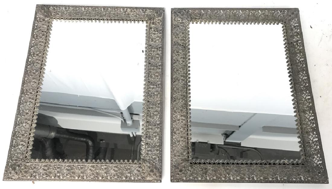 Pair Antique Silver Toned Filigree Framed Mirrors: Lot includes 2 mirrors. Metal frames, openwork filigree design. Each mirror has intricately detailed silver toned frames with ornate floral leaf and vine detail. Some discoloration to metal and wear t