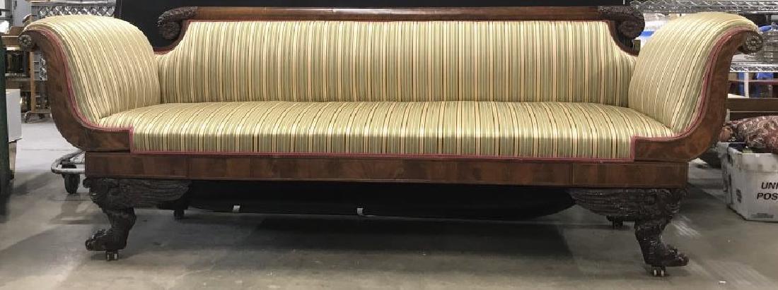 Upholstered And Carved Empire Style Sofa: Striped silk upholstery in good condition, high scrolled wood arms with brass florets decirstevi elements, Back is glossy finish to wood with scrolled snail form ends carved, Feet are richly carved wi