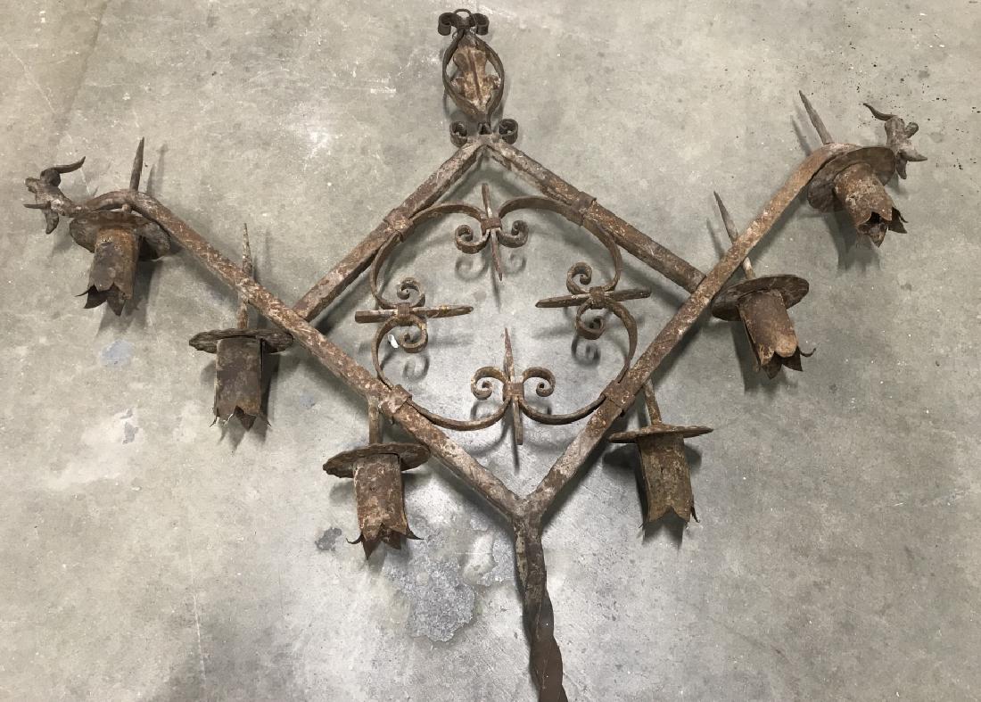 Antique Gothic Style Hanging Iron Metal Candelabra: Gothic style hanging iron metal candle holder, candelabra with dragon figurehead end details. Piece has 6 metal candle holders stylized as flowers, with a quatrefoil center. Twisted iron metal rod ext