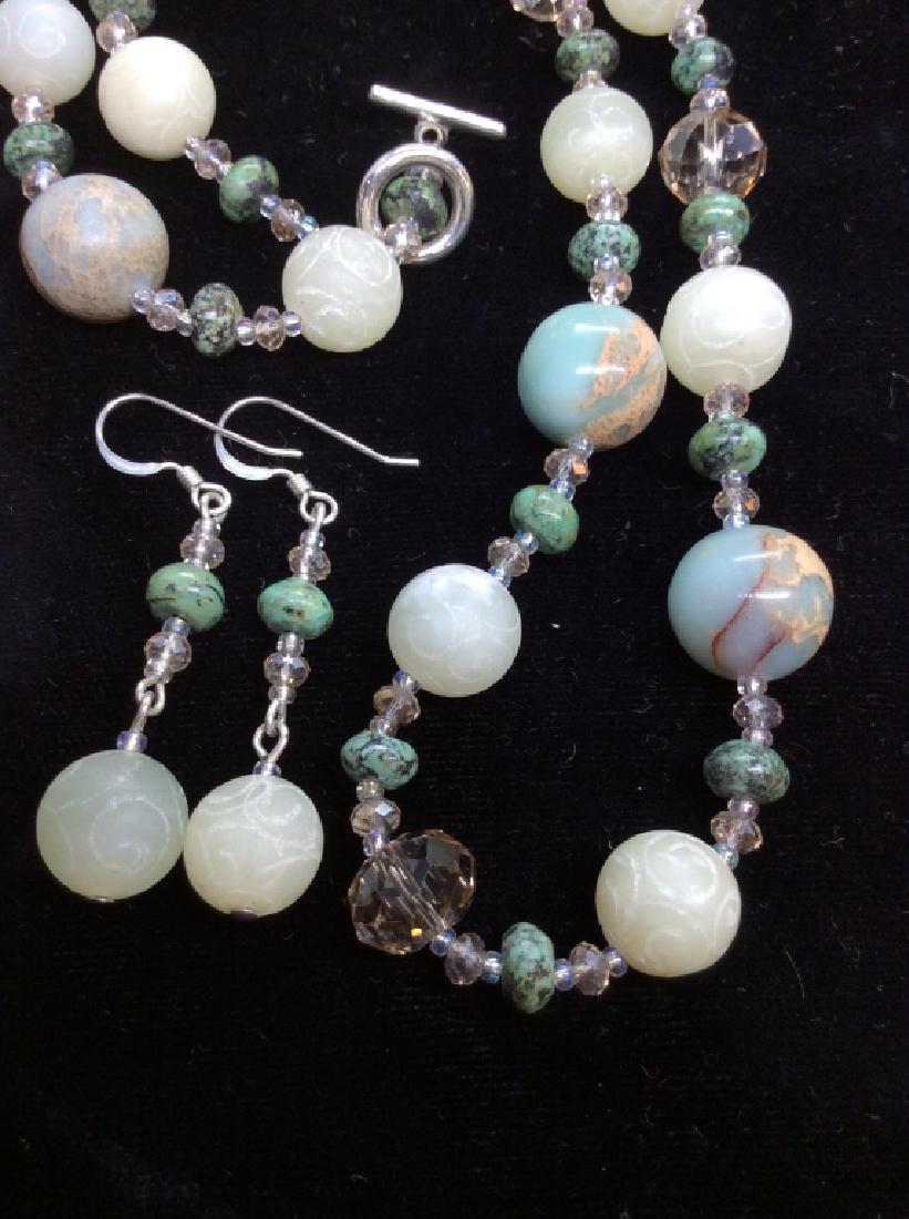 Natural stone Bead Jewelry Set: Green toned natural stone, lighter stones with carved details, silver toned metal clasp and earring loops, crystal style faceted spacer beads. Necklace and matching pierced earrings. measures app 7 in