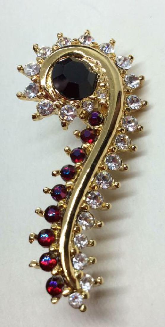 MONET Rhinestone Brooch Pin: Women’s vintage rhinestone brooch pin, gold toned metal body, with block, white and red rhinestone details. measures app 3 in long . Women’s vintage estate jewelry, statement jewelry, vintage cost