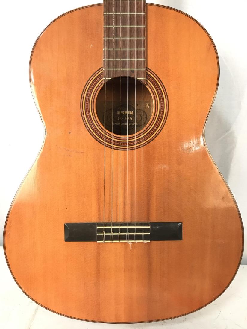 YAMAHA G50A Acoustic Guitar: Interior of instrument reads YAMAHA G50A NIPPON GAKKI CO LTD. Piece is brown and light cognac toned. Measures approx 39 inches long 14.5 inches wide 4 inches deep. Includes black toned case. Contains 