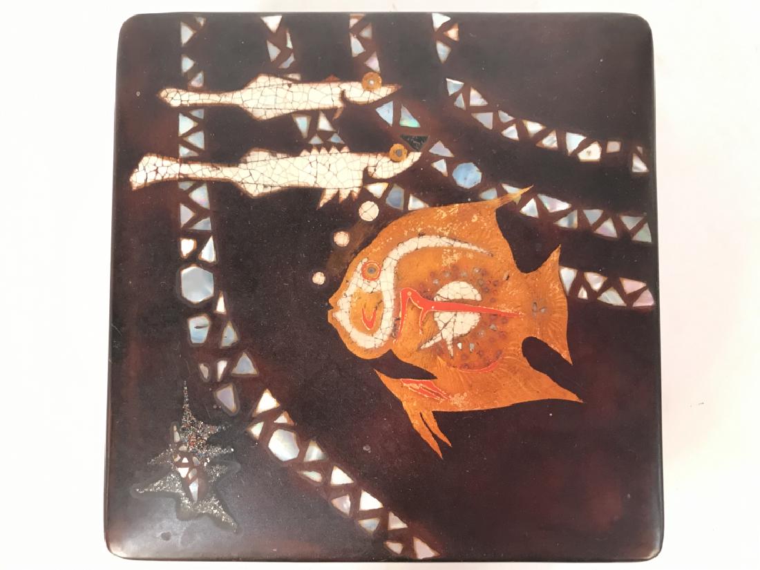 Wooden Keepsake Box W Mother Of Pearl Inlay: Box is dark mahogany toned. Includes lid. Lid of box contains intricate Mother of Pearl detail with fish detail. Measures approx 7 inches square 3 inches tall. tribal design, geometric inspired design