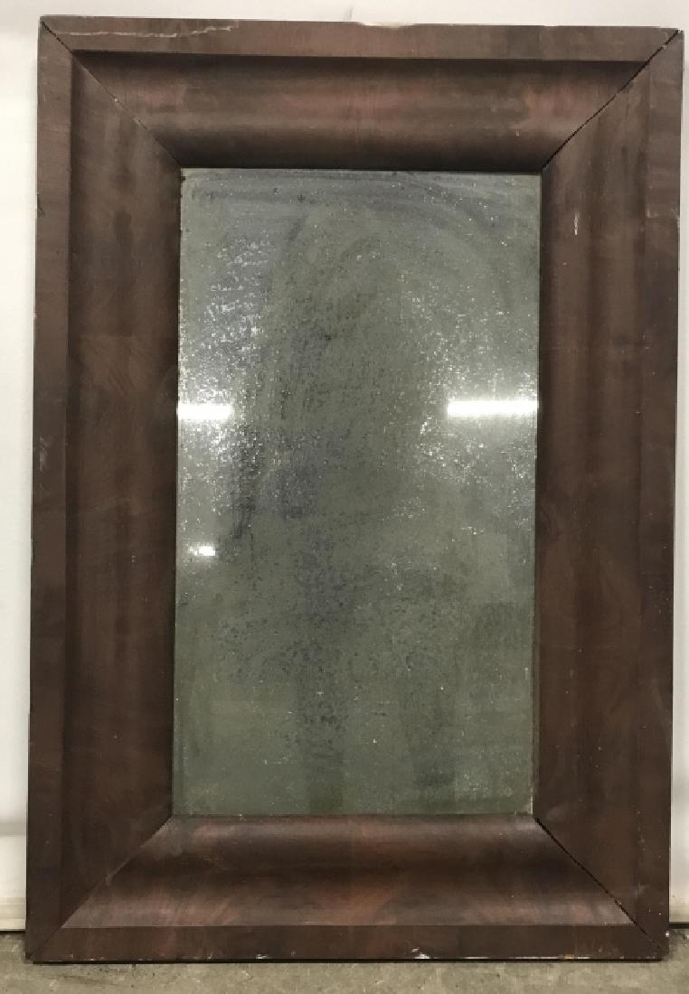 Foxed Antique Style Mirror in Wood Frame: Antique style mirror with foxing in deep tone wood frame. Measures approx 27.75 inches in height by 19 inches in width. Some surface wear of frame. Interior home decor, antique style mirror, decorativ