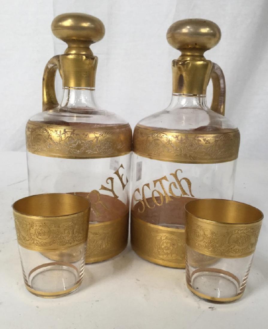 Set Gold Embossed Decanters And Cups Set: Set includes gold embossed decanter labeled Rye, gold embossed decanter labeled Scotch, each measure ht app 9 inches, each with matching glass, bar ware, table decor, table top accessories,