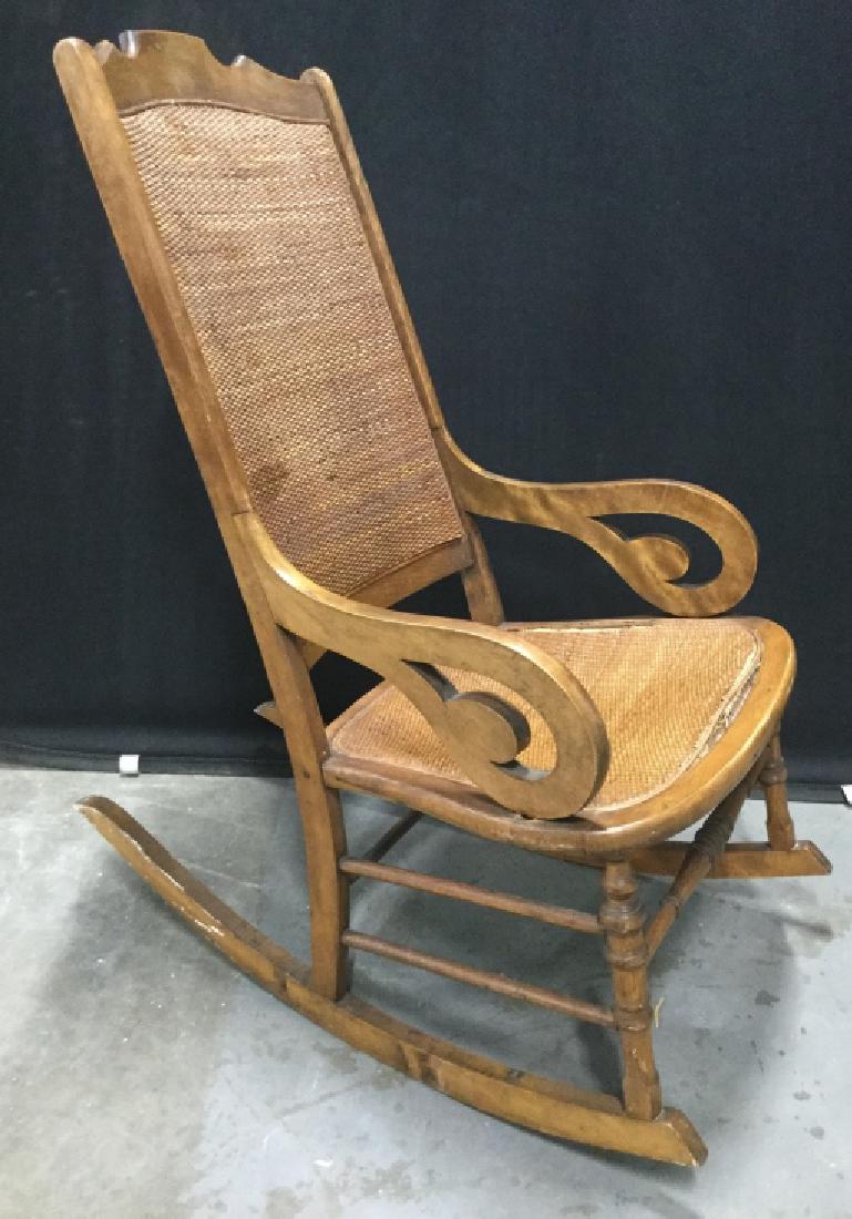 Vintage Rocking Chair W Woven Seat & Back: Vintage, possibly antique, wood rocking chair with woven rattan seat and back. Rocking chair has some surface wear, including some waving in woven seat. Measures approx 41 inches in height by 21 inche