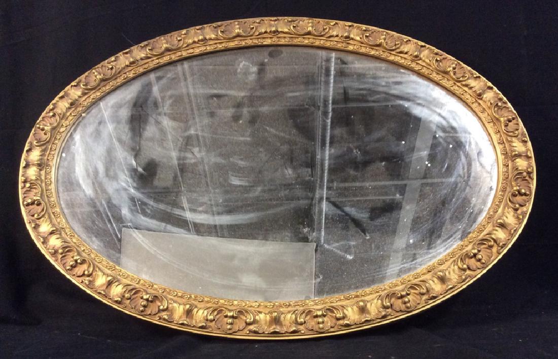 Oval Mirror in Gilt Wood Style Frame: Oval Mirror in Gilt Wood Style composite material frame. Measures approx 30.5 inches height by 20.75 inches in width. Interior home decor, decorative wall hanging. home accent, vintage/antique style m