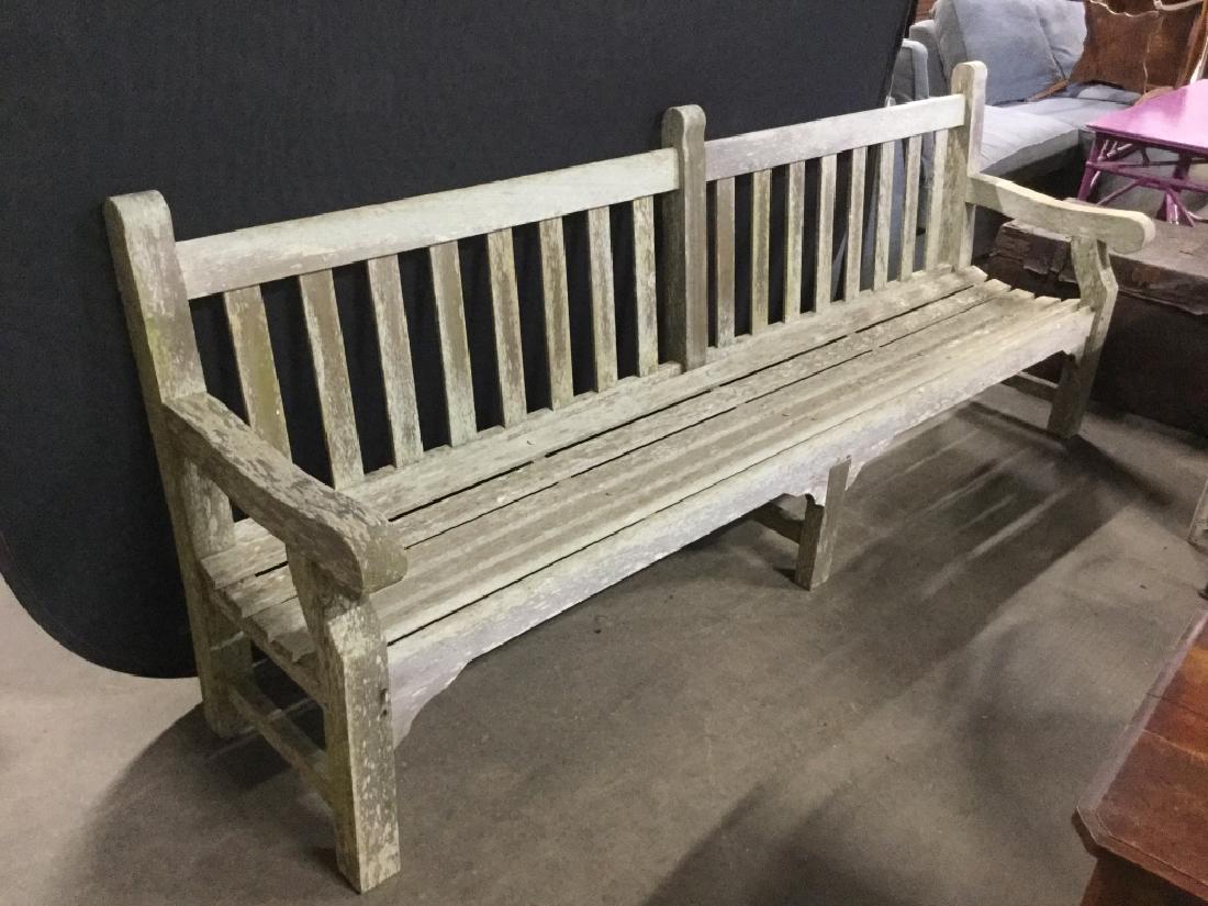 Extra Long Outdoor Teak Bench: Extra long outdoor teak Bench. Bench is grey in tone. Marked with metal plate on side, although surface of metal plate is faded and illegible. Bench measures approx 96 inches in width by 37.75 inches 
