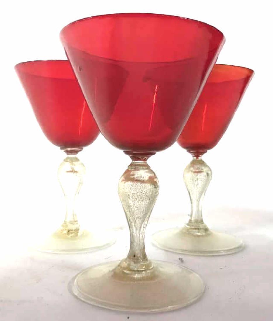Lot 3 Cranberry Art Glass Stemware: Lot includes 3 cranberry glasses with gold toned stems. Each measures approx 5 inches tall 3.5 inches wide. Gold toned stem detail is worn. bar ware, stemware, drinking goblets, wine glasses 6
