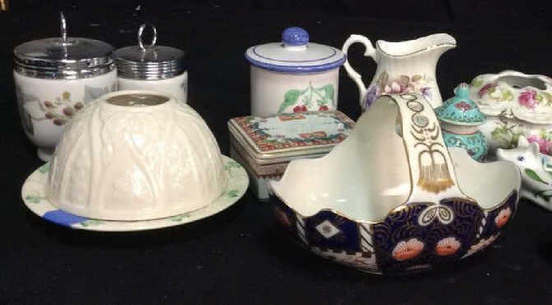 Group Lot Vintage Porcelain Collectibles: Lot includes lidded footed jars dresser top accessories, mini Asian ginger jar, Dansk cow, lidded trinket box, creamer, Italian Lidded Jar, porcelain basket, belleek porcelain tea light, ireland, bask