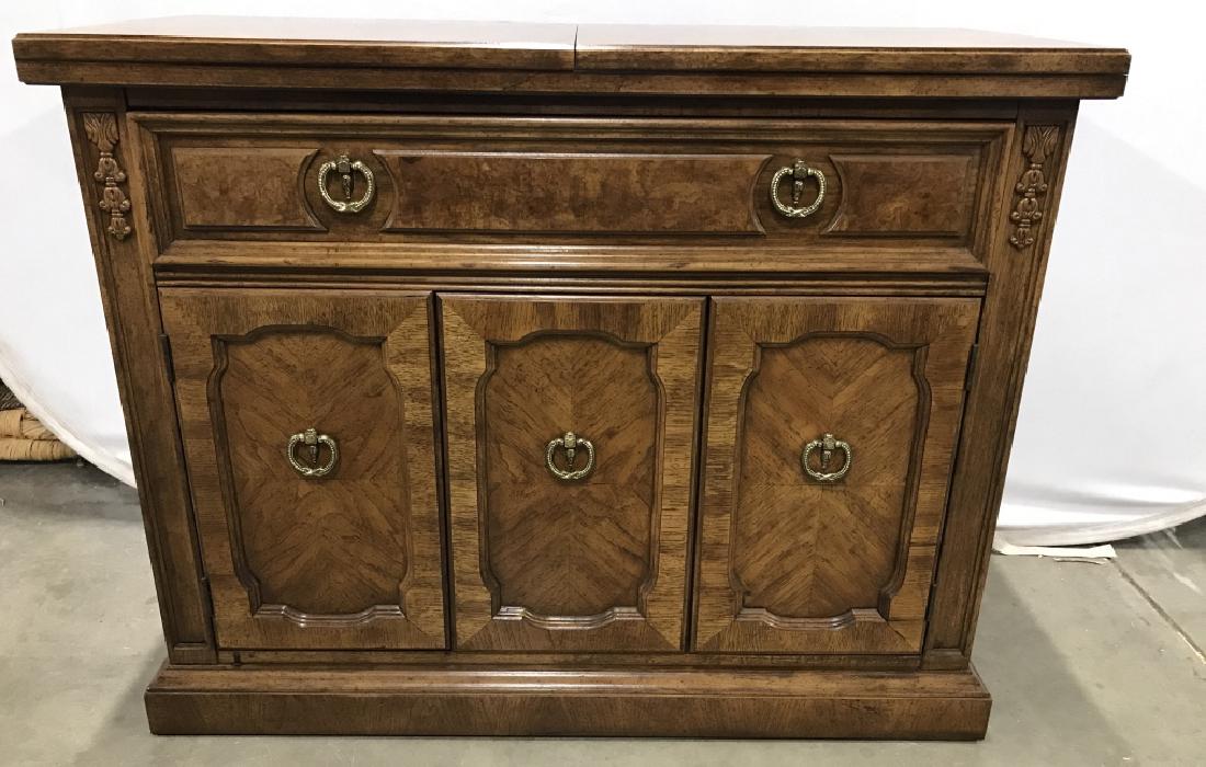 THOMASVILLE Carved Wooden Bar: Bar contains 1 drawer & 2 Cabinet doors. Top of piece flips open to reveal black toned surface. Contains carved wooden detail. Piece has gold toned metal handles. Measures approx 40 inches long 32 inc