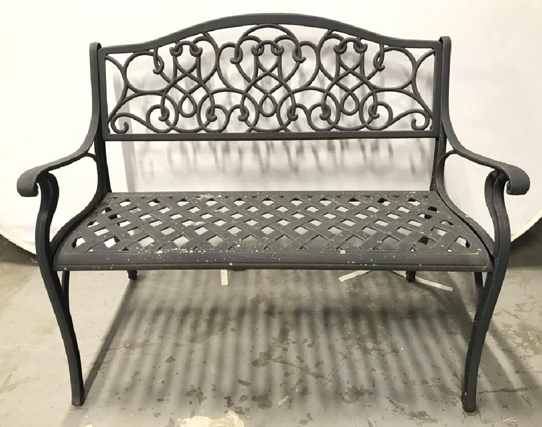 Black Toned Outdoor Metal Bench: Bench is metal seat contains woven style detail backrest contains c and s curve detail. Bench has armrests. Measures approx 43 inches long 37 inches tall, 27 inches deep. Contains some weathering. gar