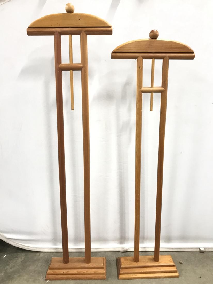 Lot 2 Wooden Valet Stands: Lot includes 2 valet stands. Each are wooden. Both have a beige tone. Largest valet stand measures approx 63 inches tall stall 18 inches wide 7 inches deep. Suit hangers, valet stands, home accessory,