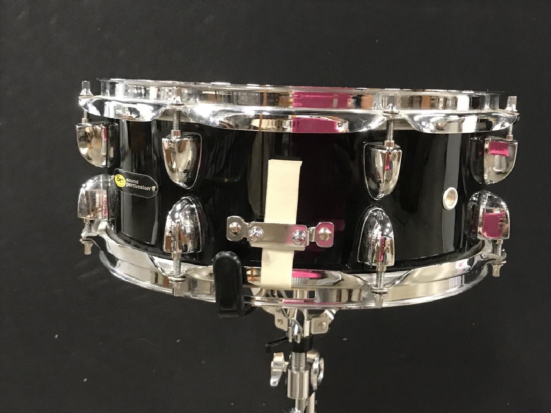 EVANS Black & Silver Toned Drum: Top of drum reads EVANS. Drum is black and silver toned. Has tripod like structure at base. Measures approx 35 inches tall 24 inches wide at base. Has evident wear. Musical instrument, drum 6.