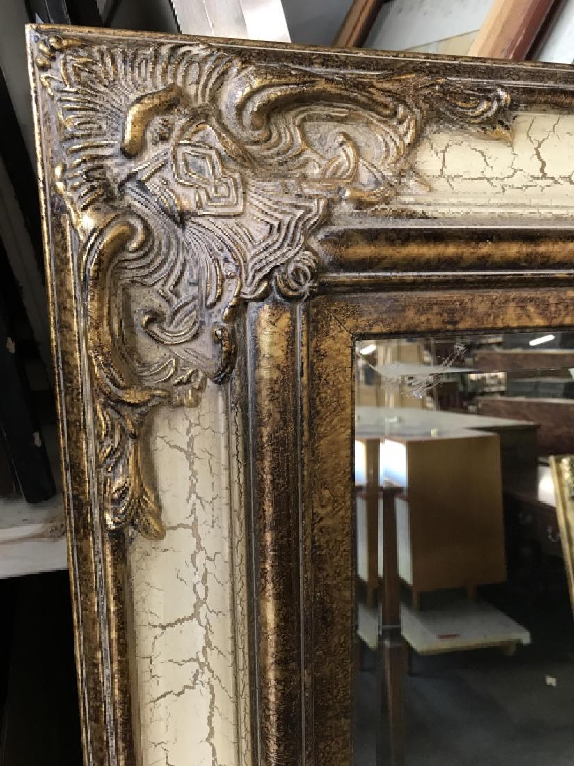 Beveled Gold Toned Mantle Mirror Beveled Mantle mirror: Beveled Mantle mirror with ornate carved frame. Frame is gold and cream in tone. Mirror measures approx 58.5 inches in height by 47 inches in width by 2 inches in depth. Antique style mirror, mantle m